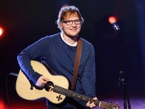In this file photo dated Sunday, March 12, 2017, British singer Ed Sheeran performs during the Italian State RAI TV program "Che Tempo che Fa", in Milan, Italy. Sheeran has told fans via Instagram that he's had a bicycle injury and posted a photo of his arm in a cast, advising fans he may have to change some concert dates with a series of shows in Asia scheduled to start on Oct. 22. (AP Photo/Antonio Calanni, FILE)