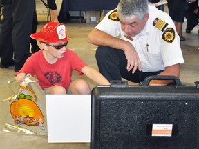 Jack Nichols (left), 9, proudly wears his fire chief hat while having a conversation with West Perth fire Chief Bill Hunter about fire safety on the farm during the West Perth fire department open house last Tuesday, Oct. 10. ANDY BADER/MITCHELL ADVOCATE