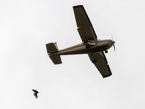 In this Oct. 7, 2016, photo, an airplane passes over the Yellville Turkey Trot in Yellville, Ark., while someone aboard drops a live turkey to the ground. (Jason Ivester /The Arkansas Democrat-Gazette via AP, File)