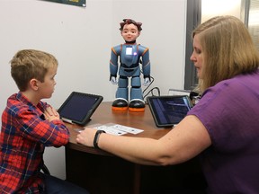 BRUCE BELL/THE INTELLIGENCER
Logan, a Grade 3 student at St. Michael Catholic School in Belleville, works with Jada Amo, an applied behaviour analysis advisor with Algonquin Lakeshore Catholic District School Board and Milo, a robot designed to help students with  Autism Spectrum Disorder.