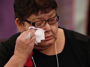 Joan Winning weeps as she speaks of her murdered niece Nicole Daniels to commissioner Michelle Audette at the opening day of hearings at the National Inquiry into Missing and Murdered Indigenous Women and Girls in Winnipeg, Monday, October 16, 2017. THE CANADIAN PRESS/John Woods