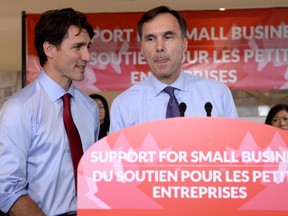 Finance Minister Bill Morneau speaks to members of the media as Prime Minister Justin Trudeau looks on at a press conference on tax reforms in Stouffville, Ont., on Monday. (THE CANADIAN PRESS)