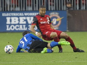 Justin Morrow is taken out of the play by Blerim Dzemalli as the Toronto FC take on the Montreal Impact at BMO Field during MLS action in Toronto on Oct. 15, 2017. (Stan Behal/Toronto Sun/Postmedia Network)