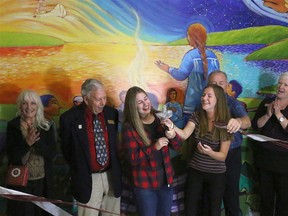 BRUCE BELL/THE INTELLIGENCER
Moira Secondary School students Sierra Brant-Heffernan and Rachel Brant get a hand cutting the ribbon from Hastings and Prince Edward District School Board members during unveiling of the tetewatate:ken project at the school on Tuesday. The mural unveiling was part of the school’s annual Harvest Festival.