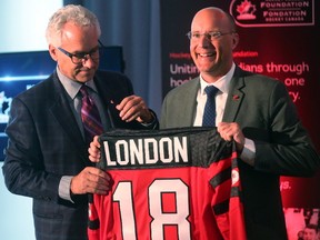 Tom Renney of Hockey Canada hands London Mayor Matt Brown a jersey after it was announced that the Hockey Canada Foundation gala and golf event will be held in London next summer. Photograph taken on Tuesday October 17, 2017. (MIKE HENSEN, The London Free Press)