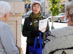 Luke Hendry/The Intelligencer
The Poverty Roundtable's Tanya Dutton tells two passersby of the need for a federal anti-poverty plan while campaigning on Front Street Tuesday in Belleville.