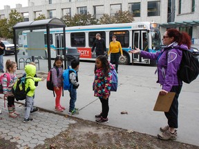 Melissa Buchan’s kindergarten class from Centennial Public School line up after using a city bus to go on a field trip to the Miller Museum of Geology on Friday. Using the new teacher field trip bus pass, Buchan and the other adults ride for free with the young students. (Julia McKay/The Whig-Standard)