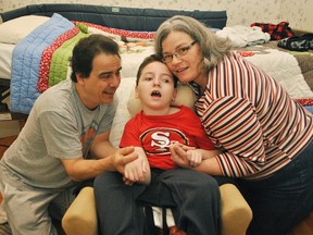 Robin Kilidjian, Ethan Kilidjian and Heather Mott are photographed in front of a specialized bed for their son, Ethan, inside their home in Chatham. Ethan has cerebral palsy and the bed was donated by the Mocha Cruisers Shrine Club.