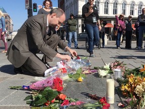 Elliot Ferguson/The Whig-Standard
Kingston Mayor Bryan Paterson places flowers in Springer Market Square in memory of The Tragically Hip’s lead singer Gord Downie on Wednesday.