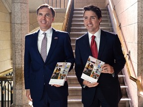 Finance Minister Bill Morneau and Prime Minister Justin Trudeau hold copies of the federal budget in the House of Commons in Ottawa. (CP photo)