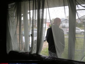 A resident stands outside a Thurman Circle home whose front window was broken by a group of men after a Thanksgiving weekend break-in in the Fanshawe College off-campus housing area near Cheapside Street in London. (MIKE HENSEN, The London Free Press)