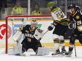 Sarnia Sting goalie Aidan Hughes makes a save on North Bay Battalion's Luke Burghardt (25) in the second period at North Bay Memorial Gardens on Thursday, Oct. 19, 2017. (DAVE DALE/Postmedia Network)