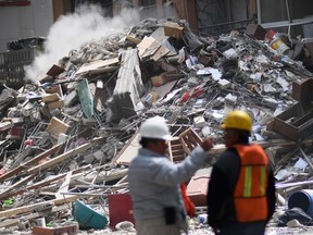 Technicians watch as a building seriously damaged by the September 19 earthquake is demolished in Mexico City on October 17, 2017. (AP photo)