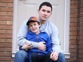 Christopher Borne and his son, Keaton, outside their home. (Gino Donato/Sudbury Star)