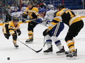 Reagan O'Grady, middle, of the Sudbury Wolves, is surrounded as he fires a shot on net against the Kingston Frontenacs during OHL action at the Sudbury Community Arena in Sudbury, Ont. on Saturday October 21, 2017. John Lappa/Sudbury Star/Postmedia Network