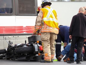 Paramedics check on a rider while firefighters examine his motorcycle following a collision between the bike and a city bus on Sunday October 22, 2017 in Belleville, Ont. The collision occurred shortly after 3 p.m. at the corner of Dundas Street East and Haig Road. Tim Miller/Belleville Intelligencer/Postmedia Network
