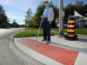Kash Husain stands in front of tactile plates installed at the intersection of Woodcraft and Viscount on Sunday October 22, 2017. Husain is a visually impaired Londoner who is an accessibility advocate. (MORRIS LAMONT, The London Free Press)