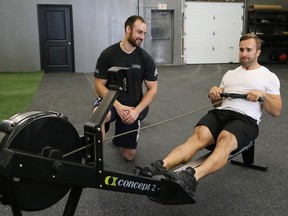 Co-owner and head coach Brad Hogue, of True North CrossFit, looks on as Joshua Bertollo goes through his exercise routine at the gym on Friday. (John Lappa/Sudbury Star)