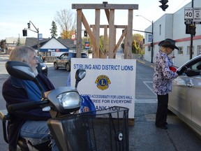 Terry Vollum/For The Intelligencer
Stirling Lions club member Lin Clarke accepts a cash donation from a passing motorist at the local service club’s toll booth fundraiser held last Saturday in the village. The six-hour event, staged to help fund handicapped accessibility at the Lions Hall, raised $3,810 for the cause. Bill Seeley, Stirling’s very own ‘Man in Motion’ was on hand to lend his support.