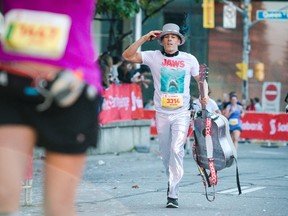 Joseph Reid, dressed in tribute to The Tragically Hip's late lead singer Gord Downie, races towards the finish line of the Toronto Marathon on Sunday. (Christopher Katsarov/The Canadian Press)