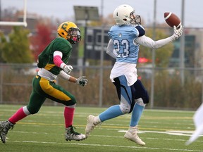 Max MacGilivray of the St. Benedict Bears makes the catch as he is pursued by Lucas Sprack of the Confederation chargers during senior boys high school semifinal football action in Sudbury, Ont. on Monday October 23, 2017. Gino Donato/Sudbury Star/Postmedia