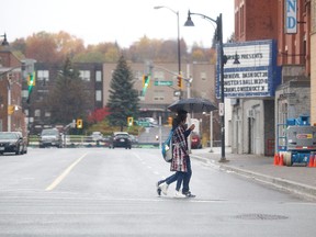 Gino Donato/Sudbury Star/Postmedia Network
Pedestrians walk in light rain in Sudbury on Monday. Umbrellas will be the fashion accessory of the week as rain is forecast every day into the weekend.
