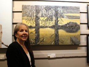 Johanne Levesque stands before her acrylic painting “Epinettes Noires” which took the NOAA award during the 61st annual Juried Exhibition.