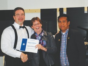 Mahlon Kitching (l.) receives first-place award from Division Director Joan Petruk (c., and Drayton Valley Derrick Toastmaster President/Area Director Von Erik Tandoc (r.).