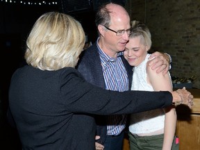 Lynne Cram, left, and David Smith, children of Joan Smith, embrace Ashley Wyatt after she spoke at a Tuesday ceremony announcing the Smith family?s $1-million donation to Youth Opportunities Unlimited. Wyatt, who is recovering from drug addiction and a bout of mental illness, works at YOU?s restaurant. (MORRIS LAMONT, The London Free Press)
