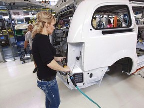 A worker on the production line at Chrysler's assembly plant in Windsor, Ontario, works on one of their new minivans on Tuesday, January 18, 2011. THE CANADIAN PRESS/Geoff Robins