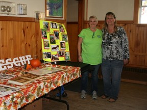 Michelle Layton, Bow Wow Rescue operator, and Dené Coombs, assistant operator, pose with their informative and inspiring Bow Wow Rescue display at last Friday night's spaghetti supper & silent auction event at the Legion.