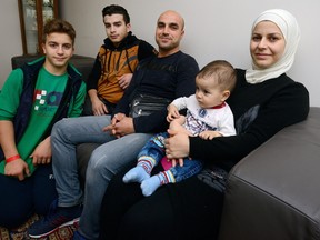 Mohammed Jadoua and his wife, Suveyd Soraz, are seen with their children, Wisam, 14, left, Jemil, 16, and nine-month-old Hasim, at the Cross Cultural Learner Centre in London Wednesday. (MORRIS LAMONT, The London Free Press)