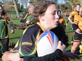 A Centennial Chargers ballcarrier gets wrapped up by Trenton Tigers defenders during Bay of Quinte senior girls rugby semi-final action Thursday at MAS Park. (Catherine Frost for The Intelligencer)