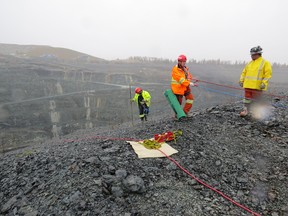 McEwen Mining’s Mine Rescue Team rappel down the side of the open pit at the Black Fox Complex on Wednesday to rescue a dog trapped on a failure. From left are Chris Price, administration manager, Dennis Landry Jr., surface maintenance supervisor, and James Lund, underground truck driver.