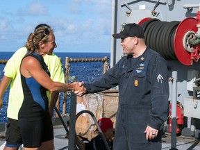 In this Wednesday, Oct. 25, 2017 photo, USS Ashland Command Master Chief Gary Wise welcomes aboard Jennifer Appel, an American mariner, one of two Honolulu women and their dogs who were rescued after being lost at sea for several months while trying to sail from Hawaii to Tahiti. (Mass Communication Specialist 3rd Class Jonathan Clay/U.S. Navy via AP)