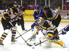 Kingston Frontenacs defenceman Jakob Brahaney, left, tries to clear the puck from in front of goaltender Jeremy Helvig as Mississauga Steelheads forward Cole Schwindt and the Fronts' Jason Robertson look on in the background during first-period action in their Ontario Hockey League game Friday night at the Rogers K-Rock Centre.