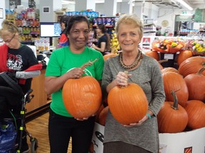 Vicki Mayer, executive director of ATN, stocks pumpkins with employee Sarjni Kumar in the Old East Village Grocer. The grocery store is nominated for a Pillar Community Innovation Award for its practice of hiring people with disabilities or who are struggling to get into the job market. (DAN BROWN, The London Free Press)