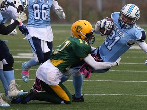 St. Benedict Bears Joshua Wilcox is hauled down by Conner Sauve of the Confederation Chargers during senior boys high school semifinal football action in Sudbury, Ont. on Monday October 23, 2017. Gino Donato/Sudbury Star/Postmedia Network