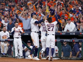Yuli Gurriel #10 of the Houston Astros celebrates with Carlos Correa #1 and Jose Altuve #27 after hitting a three run home run during the fourth inning against the Los Angeles Dodgers in game five of the 2017 World Series at Minute Maid Park on October 29, 2017 in Houston, Texas. (Photo by Jamie Squire/Getty Images)