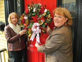 Marianne Johnstone, a member of the Captain Garnet Brackin IODE, and Sherrie Piens, owner of MP Designs at Work, hang up a wreath on a Wellington Street West home in preparation for the Christmas House Tour happening in Chatham Nov. 18 and 19.