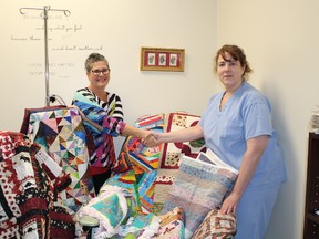 Angel Girard-Forget presents a number of finished quilts to Laurie Snook, R.N. chemo nurse. The quilts are to be given to patients using the chemo room at the Lady Minto Hospital. They are part of the Chemo Quilt Comfort Program that Girard-Forget has started.