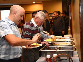 Men serve themselves food during Breakfast with the Guys at the Whitecourt Golf and Country Club on Oct. 30. The event allowed local men to learn about violence against women (Peter Shokeir | Whitecourt Star).