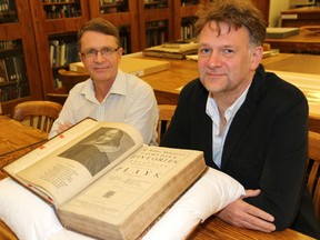Archivist Robin Keirstead, left, and Shakespearean scholar and English professor James Purkis, examine the newly-donated Shakespeare's Fourth Folio (1685) at Western Libraries Archives and Special Collections. (Contributed/Western University)