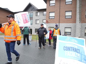 Striking faculty at Cambrian College picket near a college residence in Sudbury, Ont. on Monday October 23, 2017. About 12,000 faculty members province-wide have been on the picket line since last Monday morning after talks between the union and the College Employer Council failed to produce a tentative collective agreement. Gino Donato/Sudbury Star/Postmedia Network