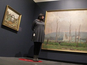 Anna Miccolis looks at a painting by J.W. Beatty at the Judith and Norman Alix Art Gallery (JNAAG) as part of the current “Witness: Canadian Art of the First World War” exhibition. A piece by A.Y. Jackson is also pictured. The gallery has brought back snapshot, red-dot tours as part of the exhibition. (Tyler Kula/Sarnia Observer)