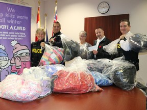 Winter outfits for the final year of Adopt-a-Child are ready for pickup at the Prince Edward OPP detachment on County Road 1. Next year the program will be known as Keep Kids Warm. Seen, from left, are Const. Kim Guthrie, Const. Pat Menard, longtime volunteer Barb Sills, Sobeys owner Jamie Yeo, and detachment commander Staff Sgt. John Hatch. (BRUCE BELL/Postmedia Network)