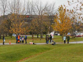 Faculty at the Kingston campus of St. Lawrence College walk the picket line in the rain on Wednesday as word comes down that both sides are heading back to the bargaining table tomorrow. (Julia McKay/The Whig-Standard)