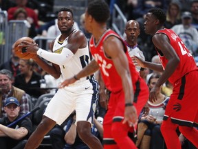 Denver Nuggets forward Paul Millsap, back left, looks to pass the ball as Toronto Raptors guard DeMar DeRozan, front, and forward Pascal Siakam, of Cameroon, defend in the first half of an NBA basketball game Wednesday, Nov. 1, 2017, in Denver. (AP Photo/David Zalubowski)