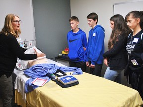 Sue Wiebenga, professional practice lead at the Chatham-Kent Health Alliance, demonstrates how an automated external defibrillator works to Grade 9 students Lucas Hottot, Porter Hamilton, Leah Thompson and Piper Phaneuf. The Chatham Campus of the hospital brought in 26 students for Take Our Kids to Work Day on Nov. 1.