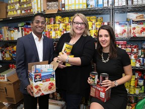 Judy Fyfe, middle, the executive director of the St. Vincent de Paul Society with Queen's University MBA Program students Elizabeth Pratt and Parthiban Nagarajah after their class donated over $22,000 to St. Vincent de Paul Society in Kingston on Thursday  November 2 2017  Ian MacAlpine /The Whig-Standard/Postmedia Network